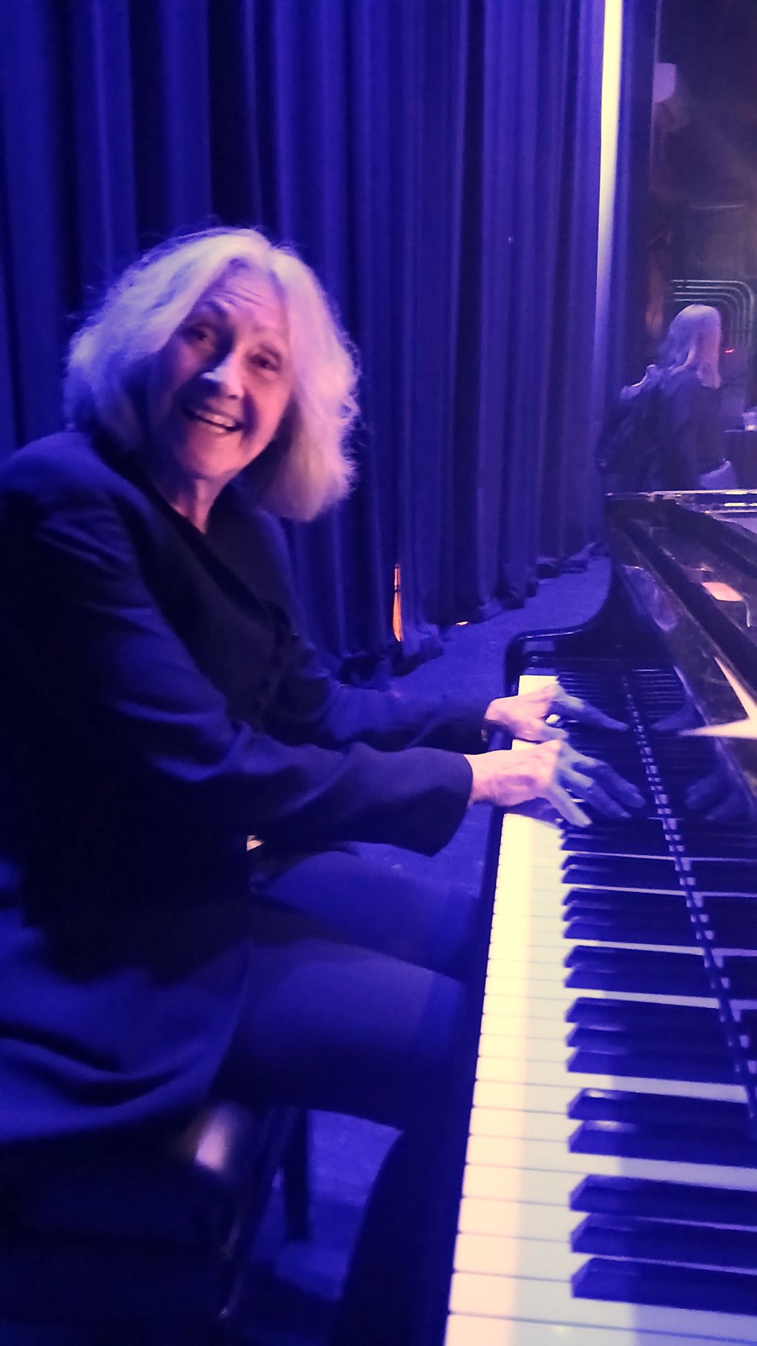 Becky Oexler playing a grand piano on stage